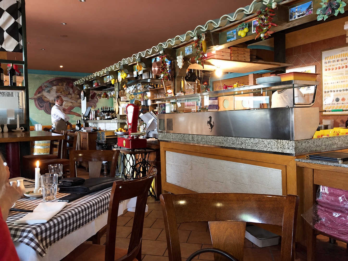 The counter and pizza station in the dining room, with set tables in front