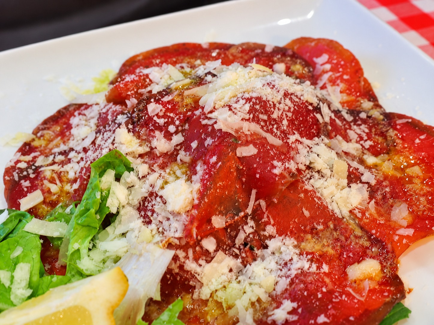 Beef carpaccio with grated parmesan, salad and lemon