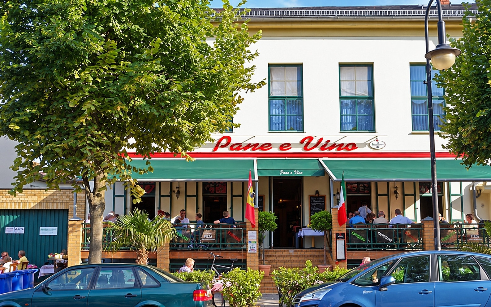 The Pane e Vino façade with green awnings and red lettering, framed by trees