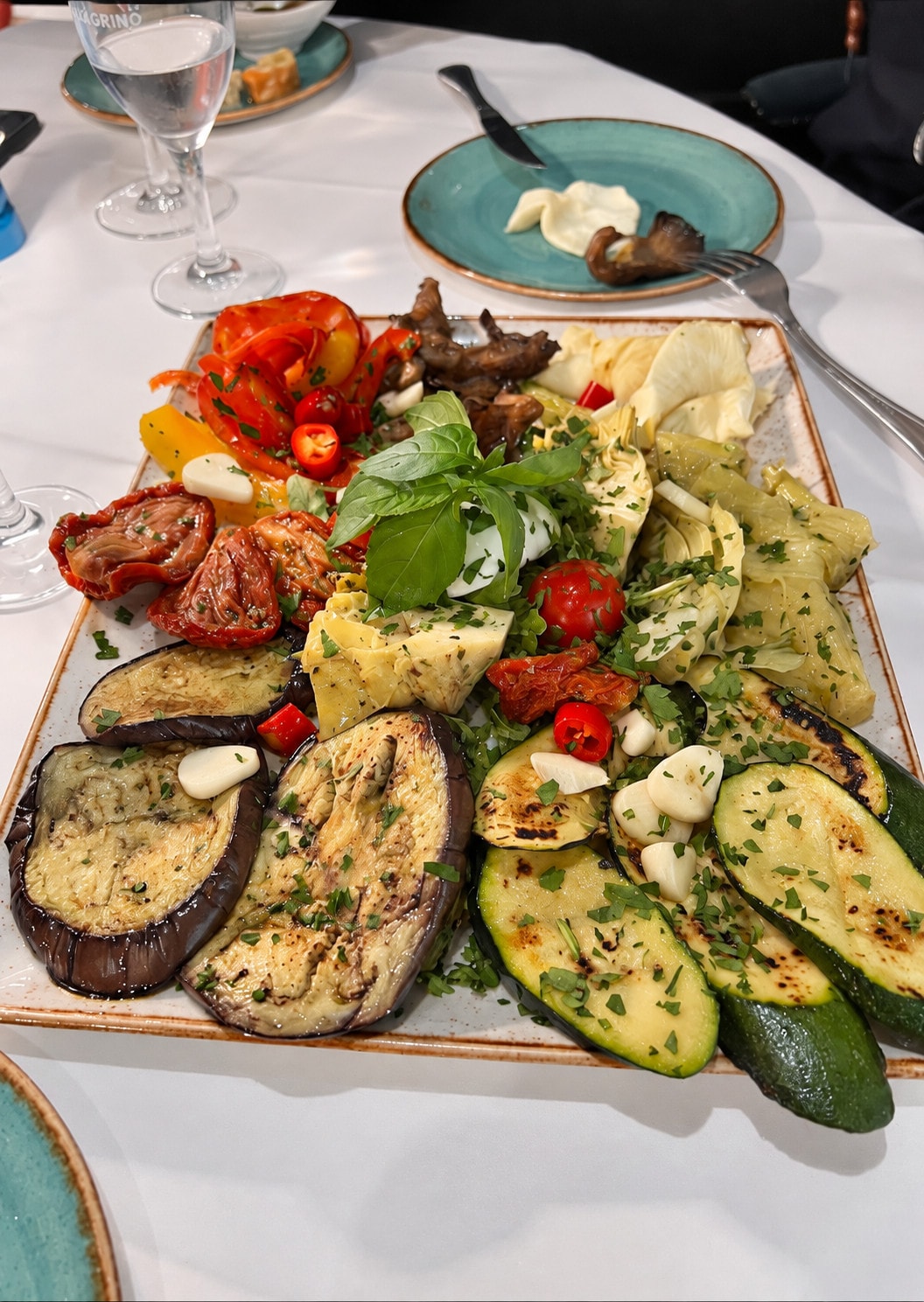 A platter of grilled courgette, aubergine, sun-dried tomato, artichoke and basil