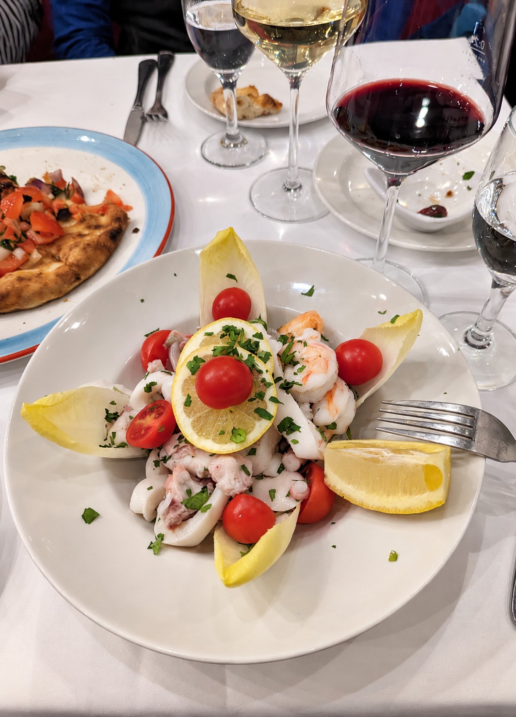 Seafood salad with prawns, squid, cherry tomatoes, chicory and lemon