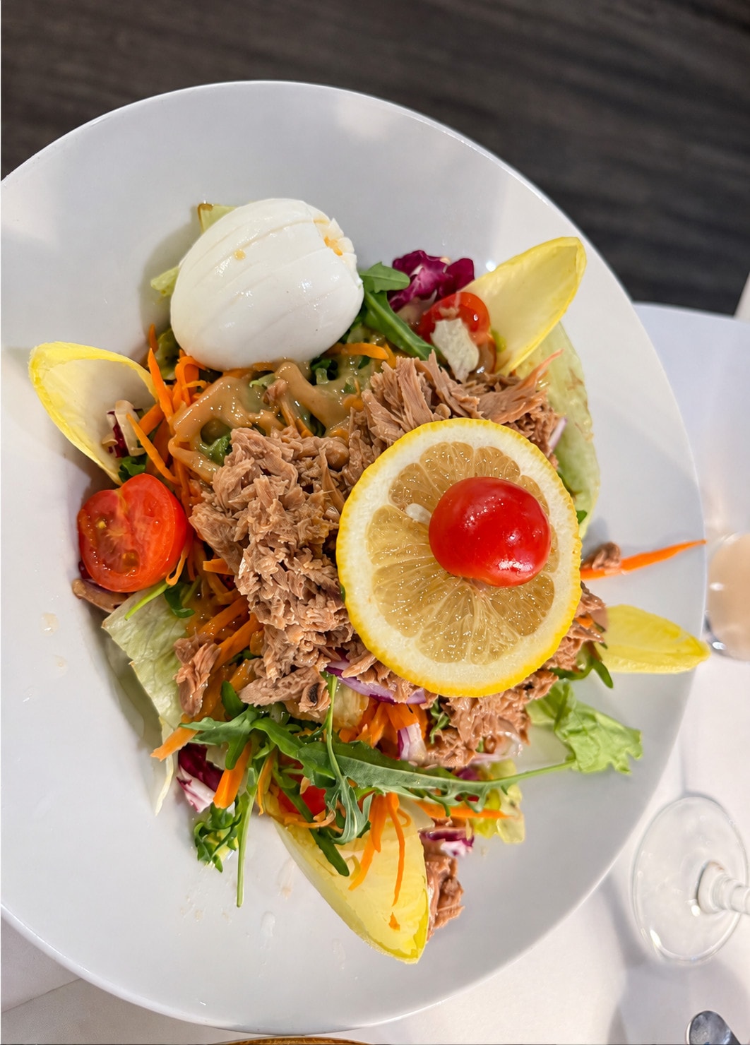 Salad with tuna, egg, carrot, rocket and a slice of lemon