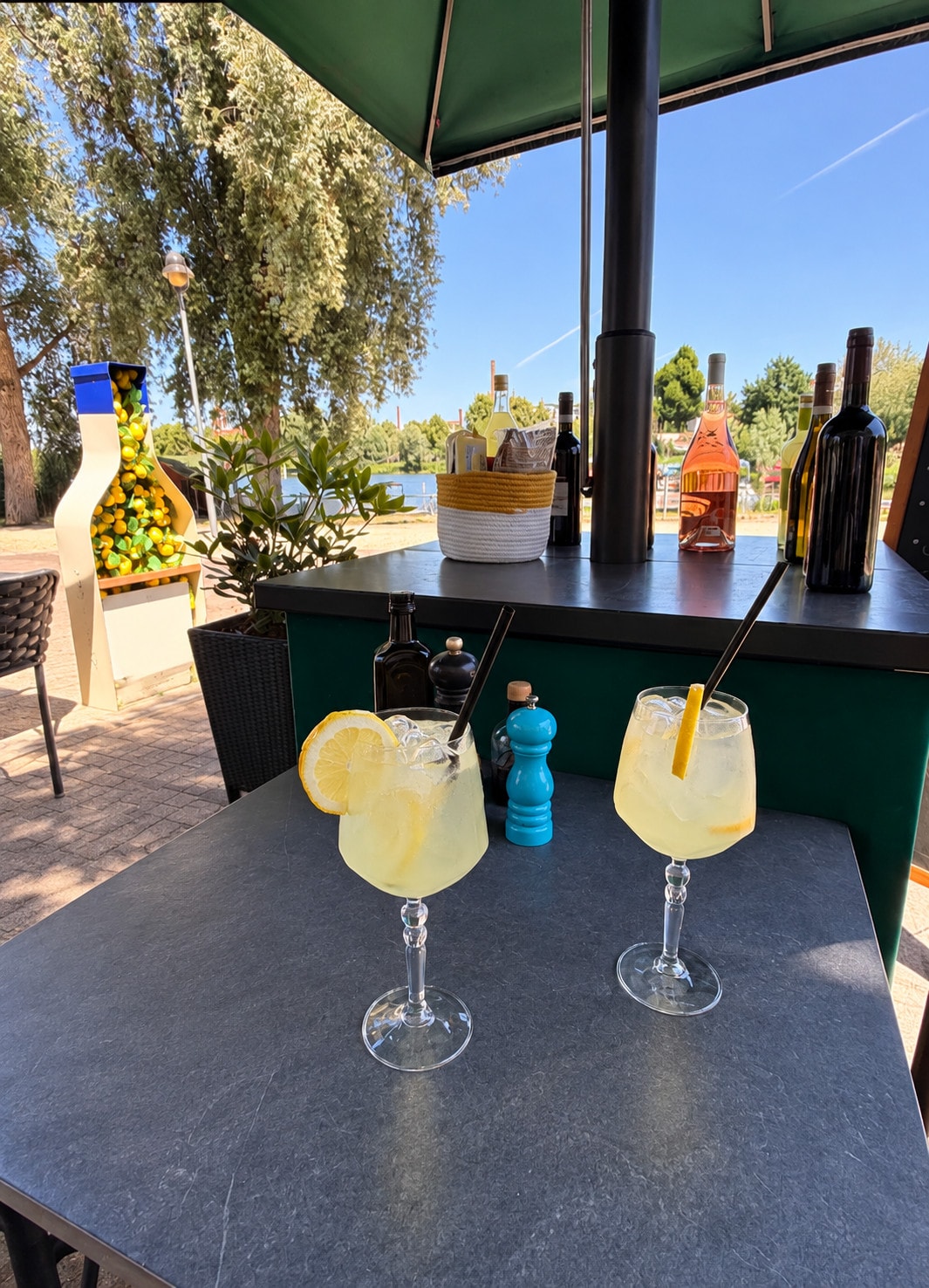 Two limoncello spritzes on the terrace with the water behind