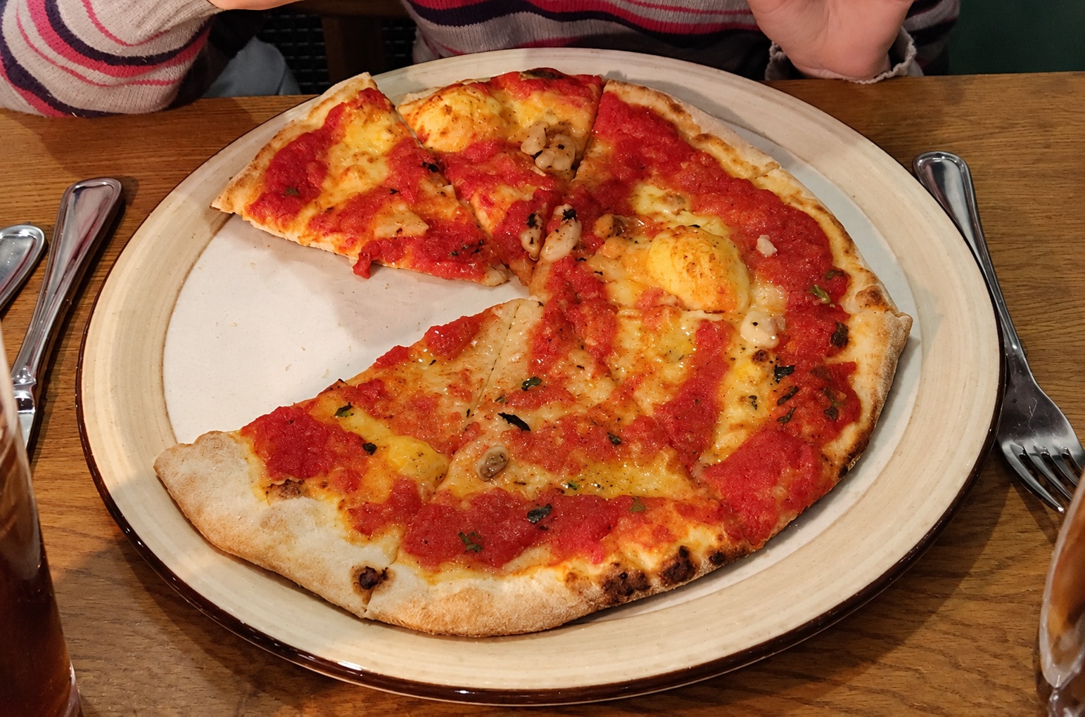 Thin pizza with tomato sauce, garlic and oregano, two slices already gone