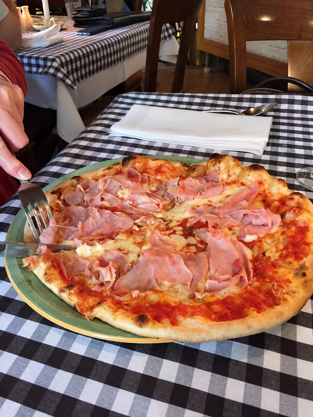 Pizza prosciutto with cooked ham on a black-and-white checked tablecloth