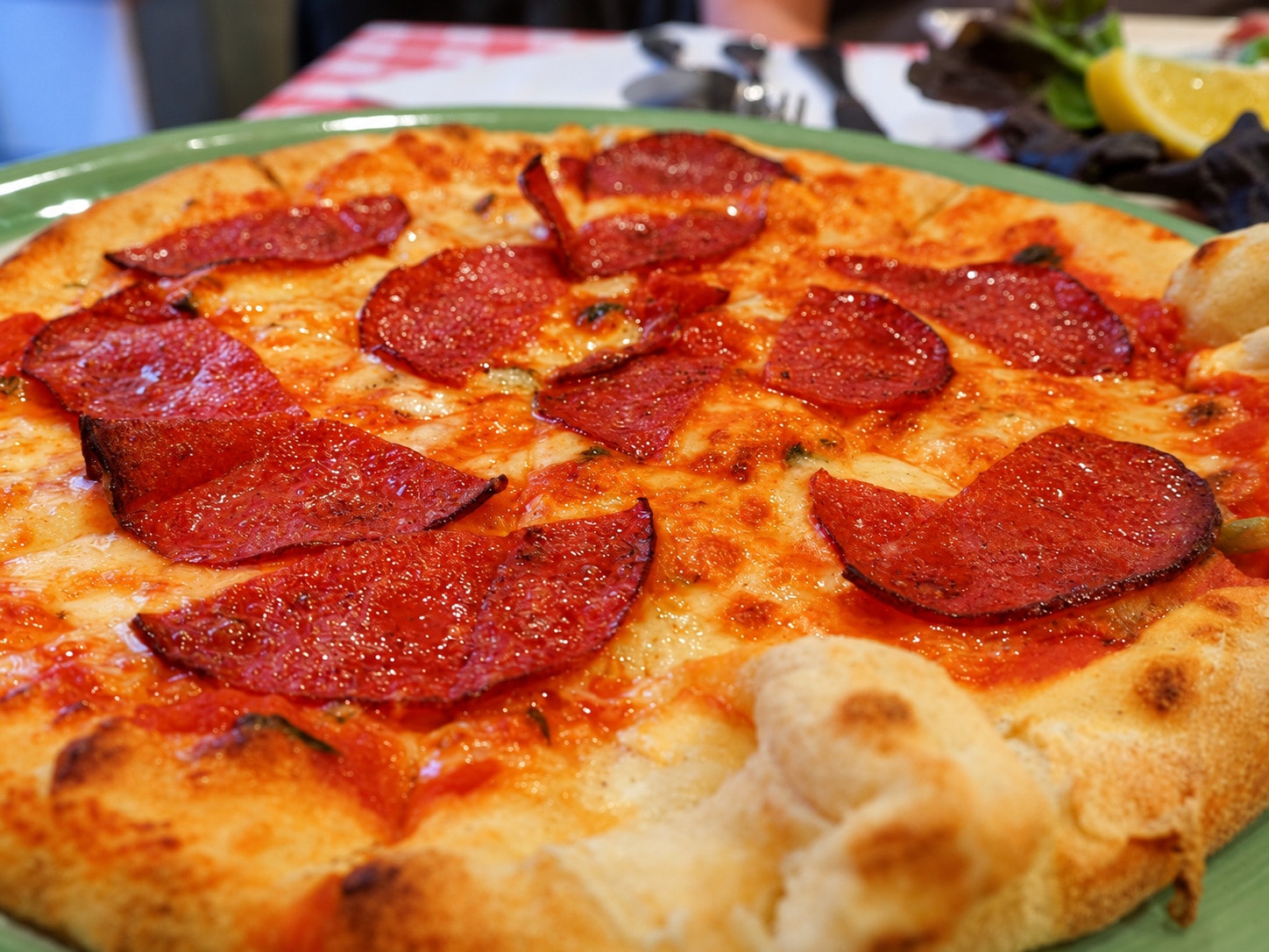 Close-up of a salami pizza with a golden crust