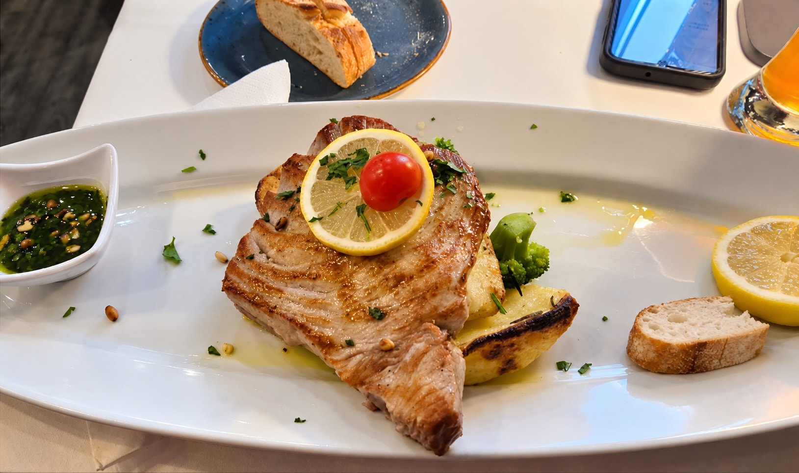 Grilled tuna steak with lemon, broccoli and herb oil